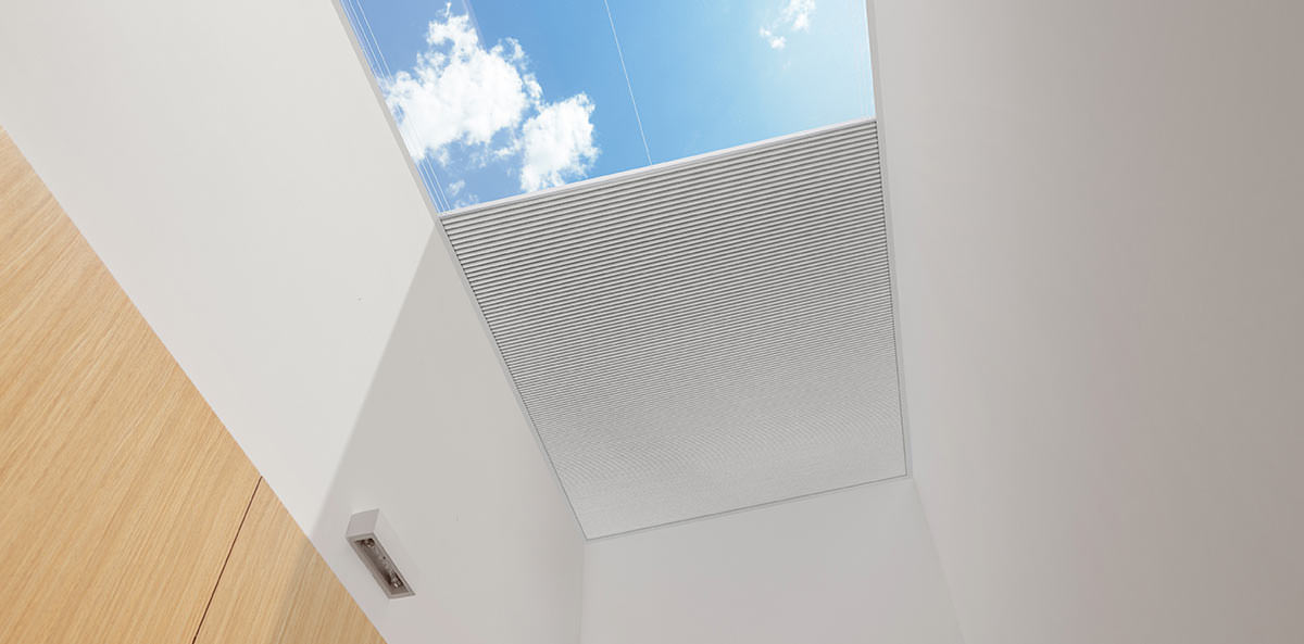 Half-drawn blind with blue skies, showcasing custom blinds from Alight Lantern Blinds