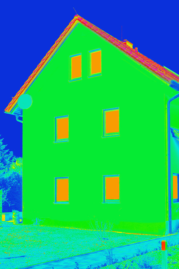Infrared Image Showing Heat Loss in a House Infrared image of a house indicating heat loss through the roof and walls